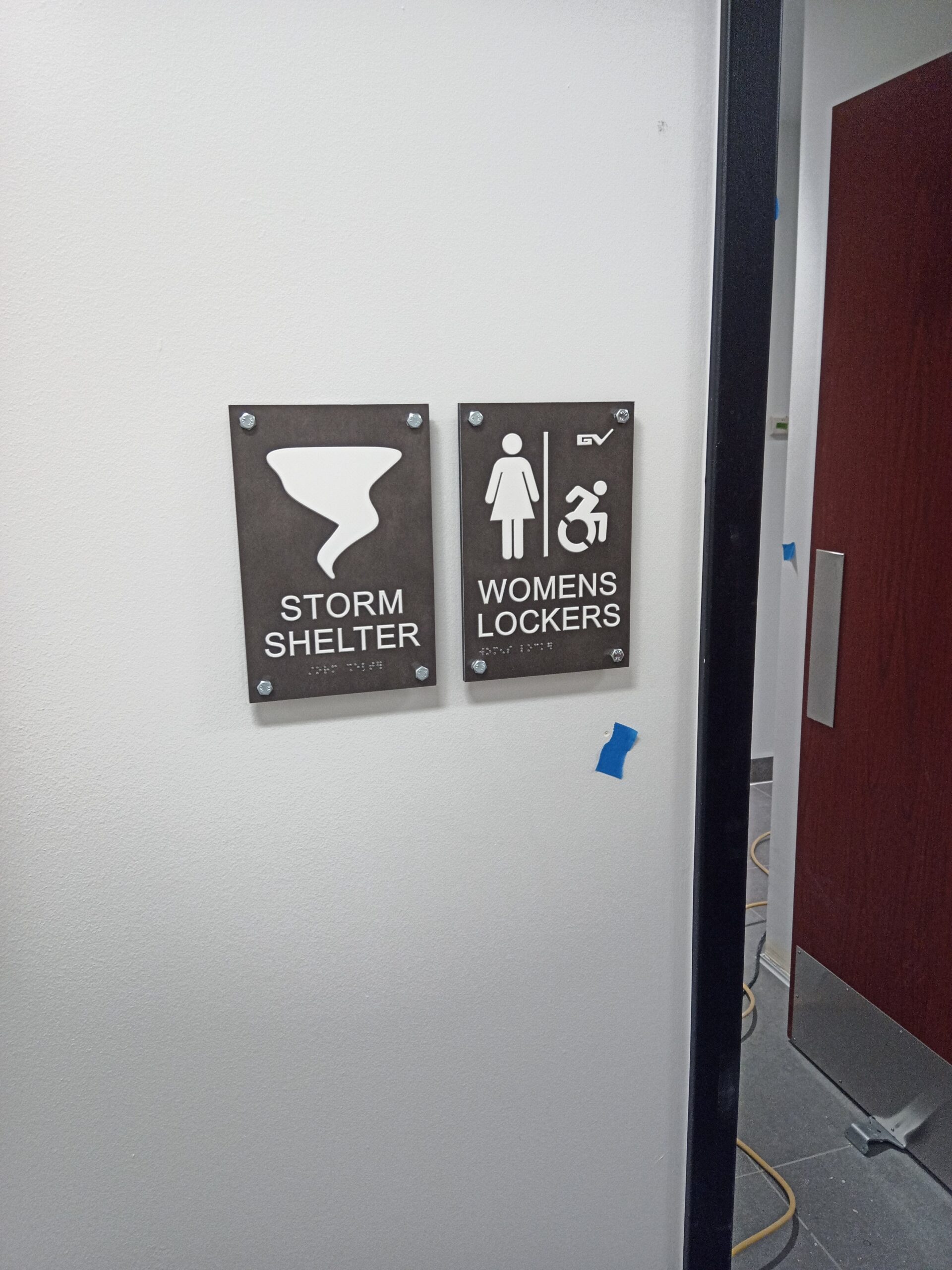 Custom ADA sign with tactile lettering and braille, high-contrast design for accessibility compliance.