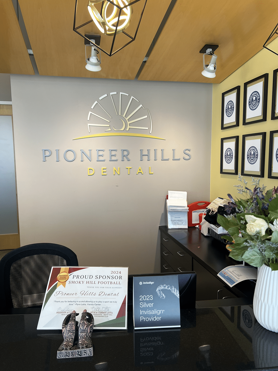 Pioneer Hills Dental reception sign behind the front desk, highlighting professional office branding.